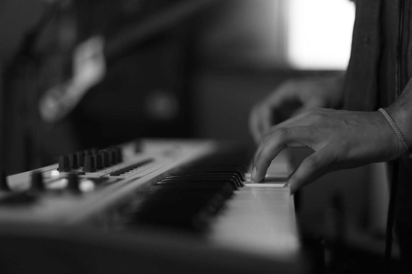 Hands playing a synthesizer.